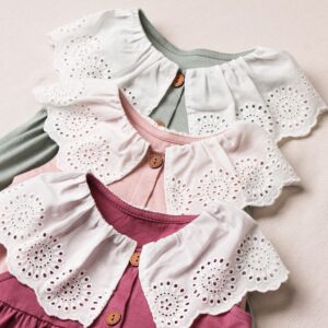 Three adorable baby dresses with lace collars in soft pastel colors. Perfect for fashion and textile enthusiasts.